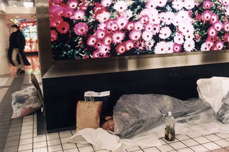THE SUBWAY: GINZA STATION. HOMELESS SLEEPING UNDER A BENCH WITH A PANEL WITH A PICTURE OF FLOWERS.
LA METROPOLITANA: GINZA. SENZA CASA DORME SOTTO UNA PANCHINA CON UN PANNELLO DI FIORI. Marco_Metro_3